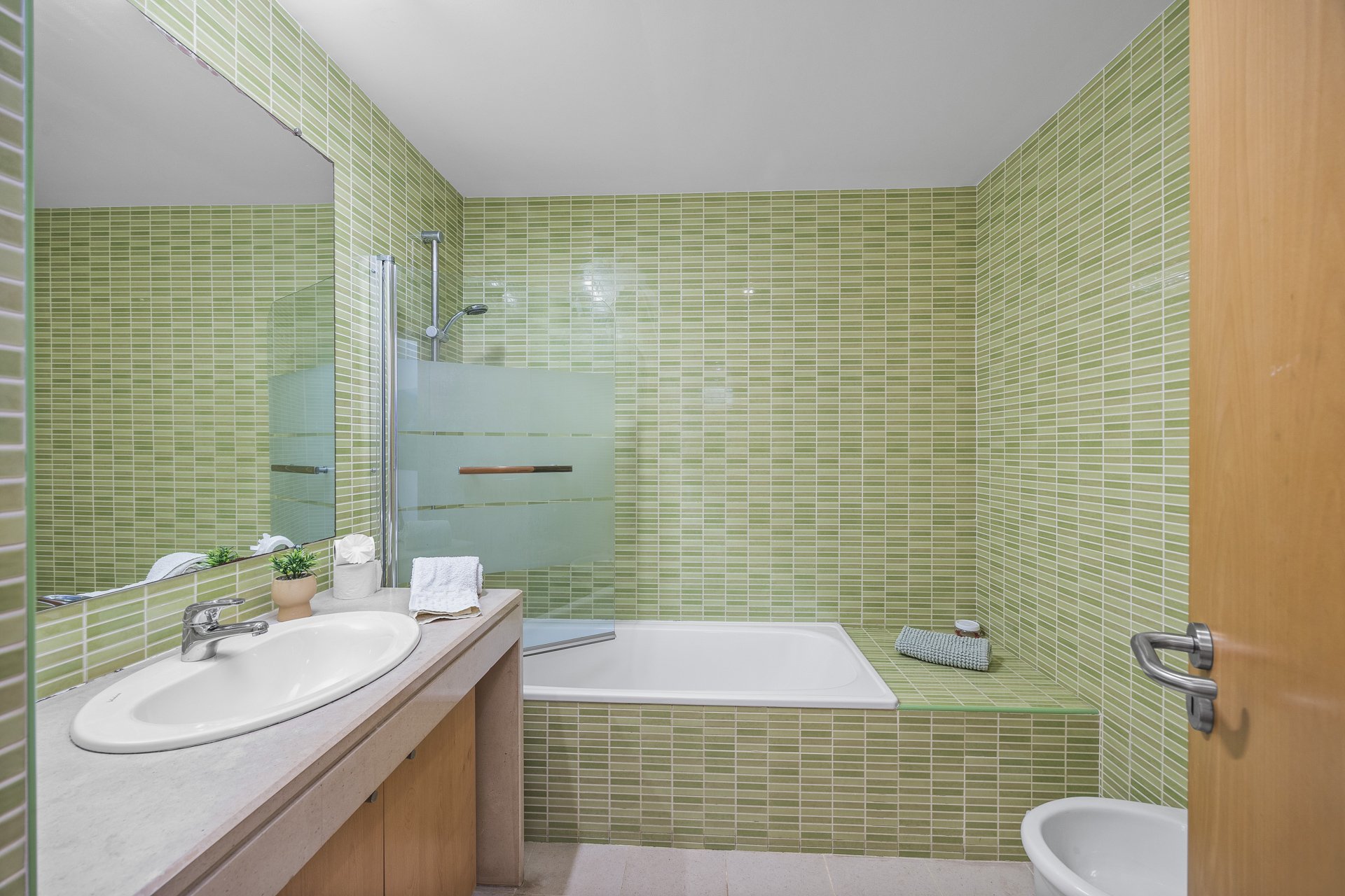 Bathroom with bathtub and green mosaic tile