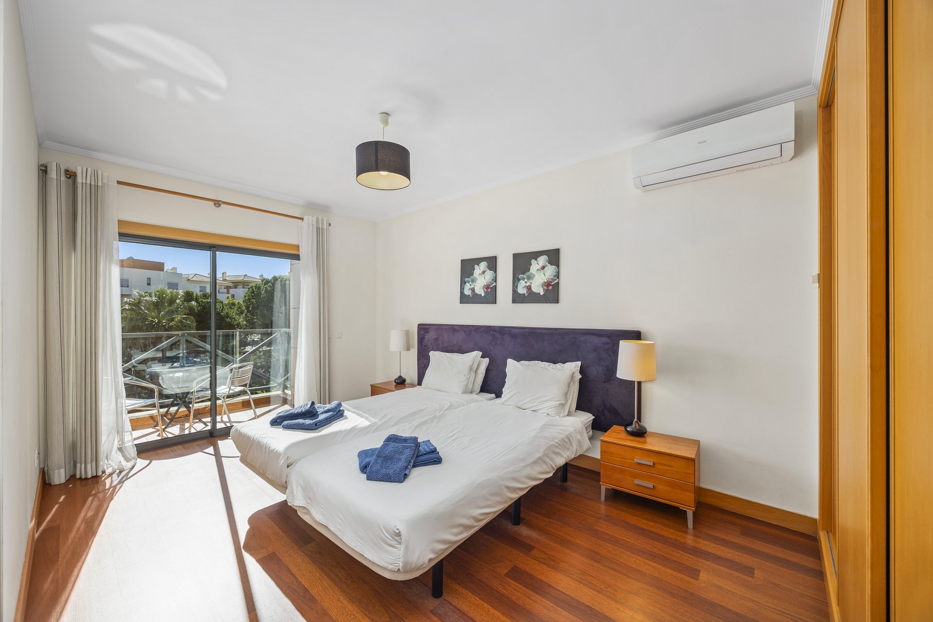 Bedroom with balcony access and purple upholstered headboard