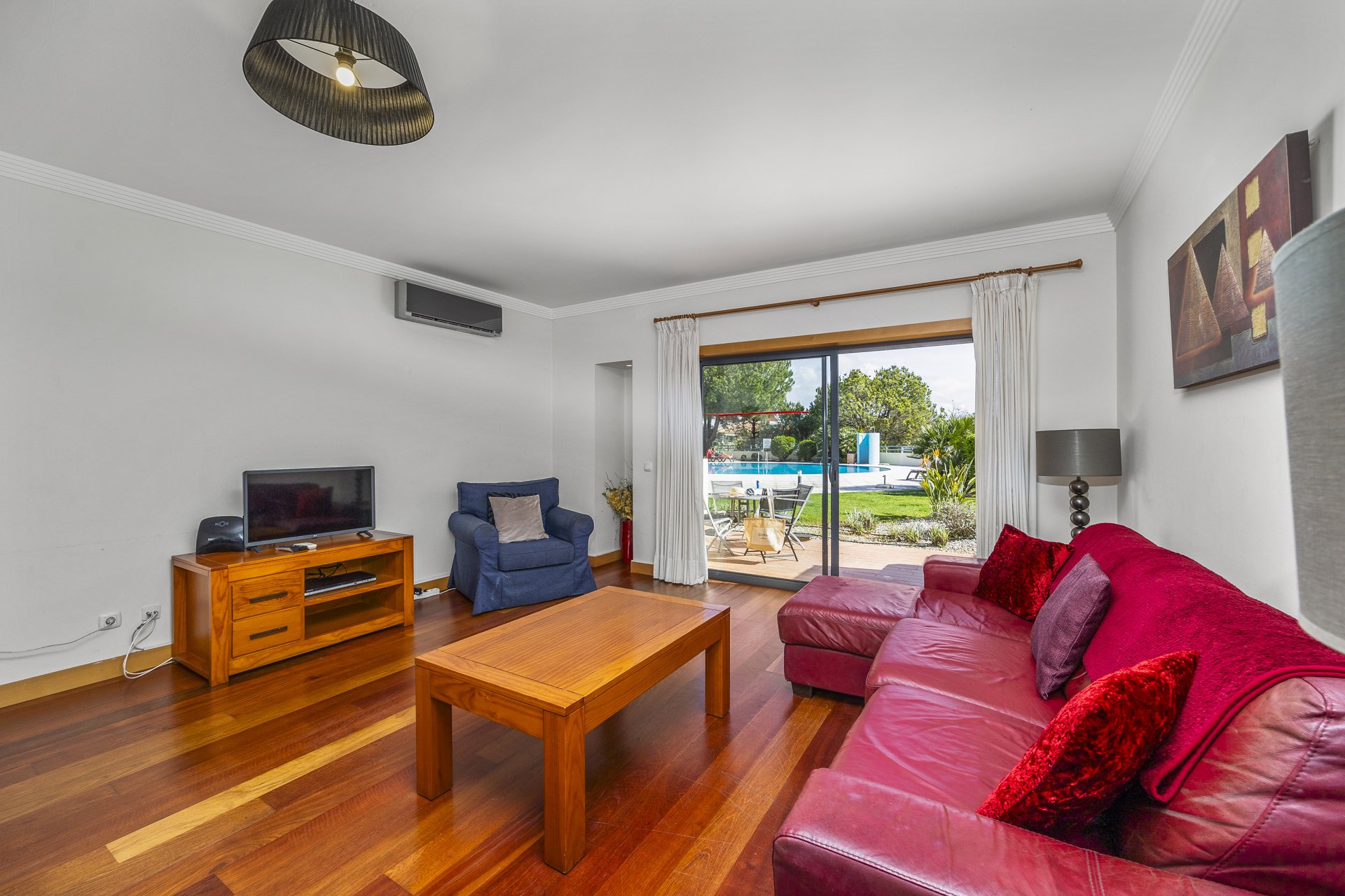 Living room with sliding doors open to the terrace and pool