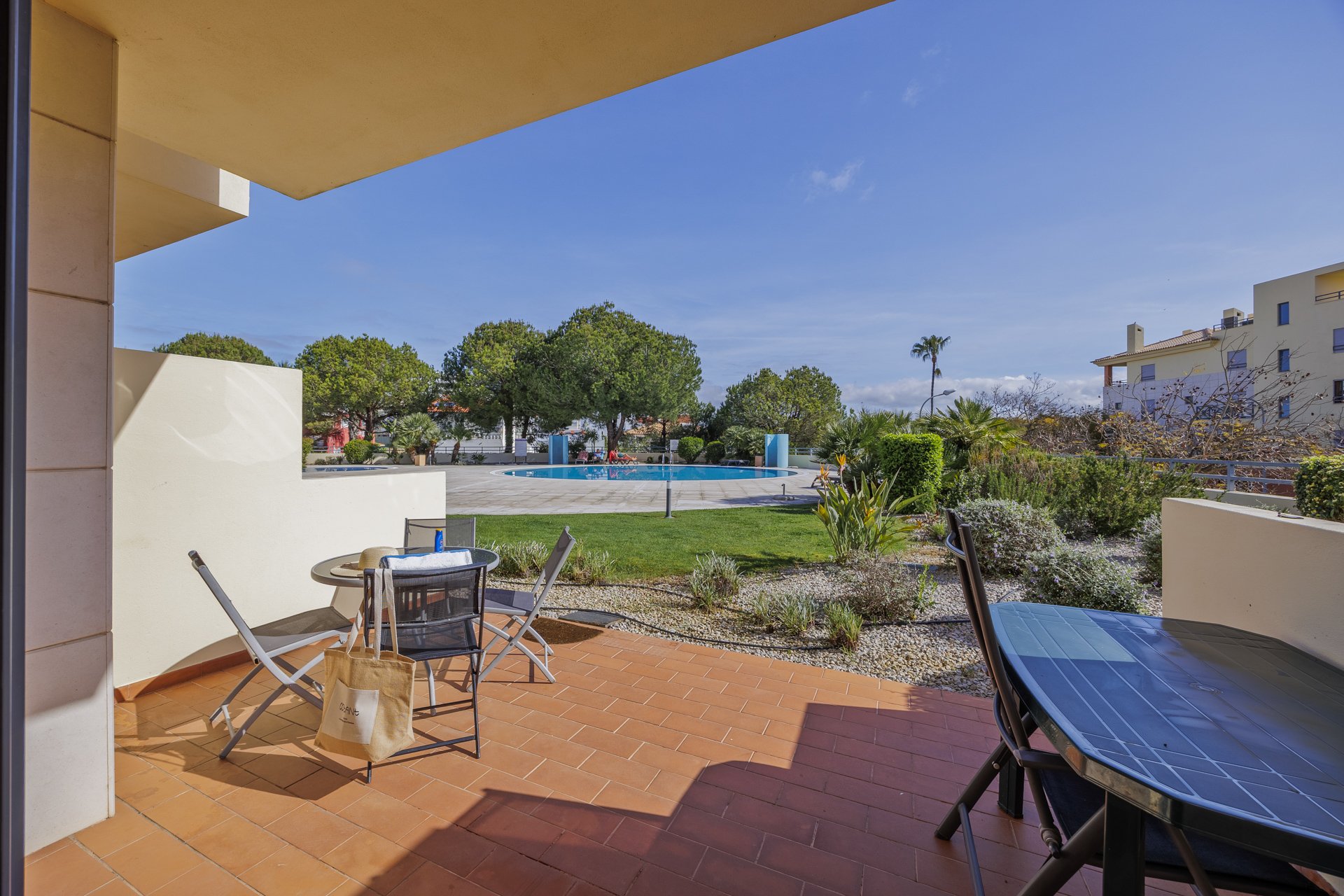 Terrace with dining table overlooking the pool and gardens