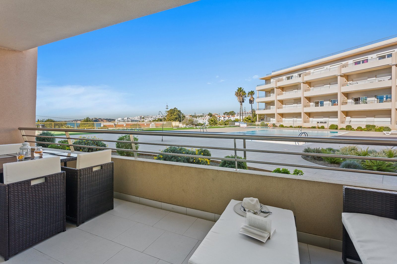Balcony seating area with pool and sea view