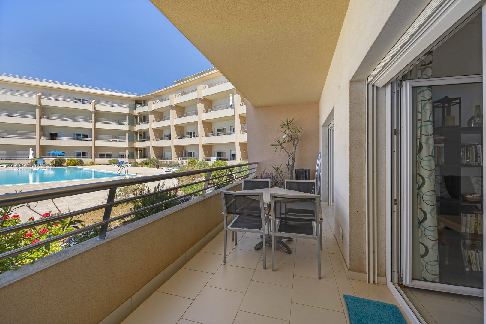 Balcony with dining table overlooking the pool