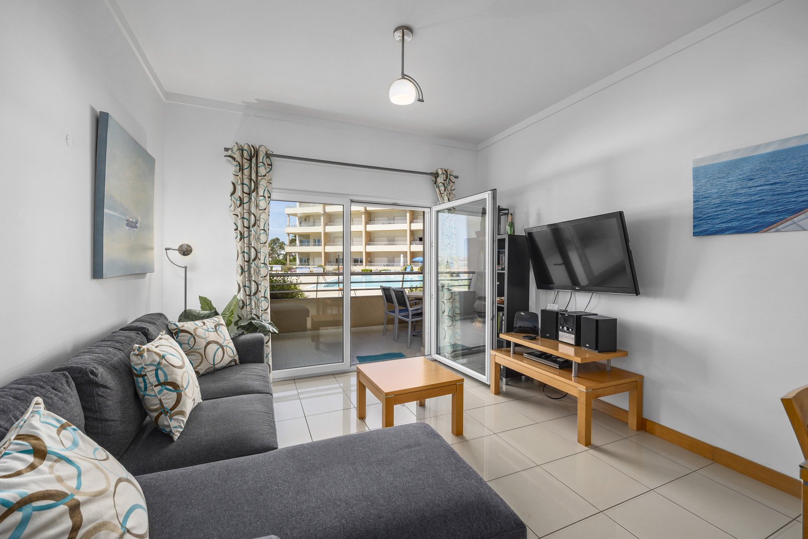Living room with balcony doors open to the pool view