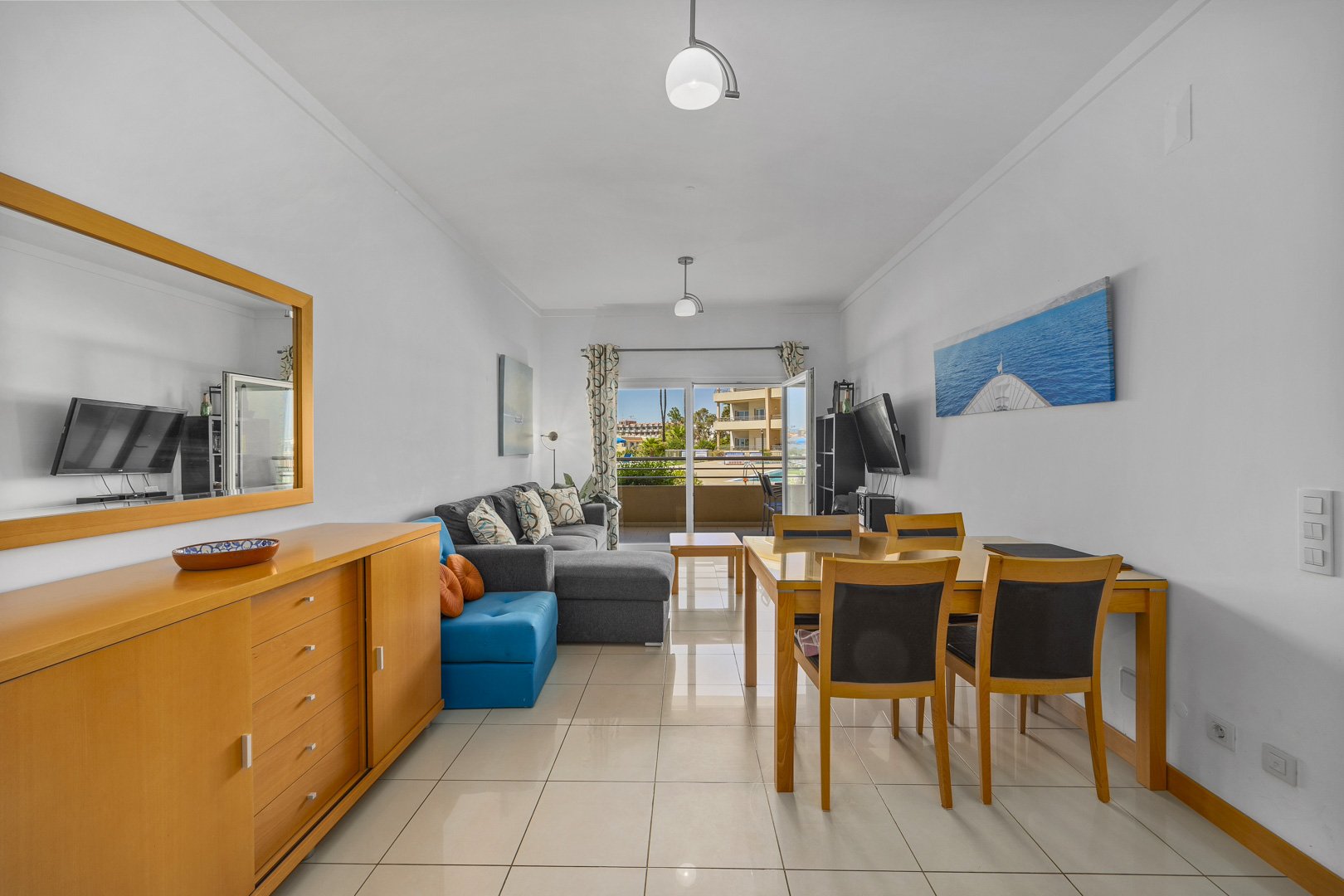 Living room with dining table and pool view balcony