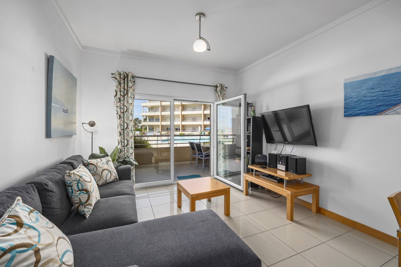 Living room with balcony doors open to the pool view