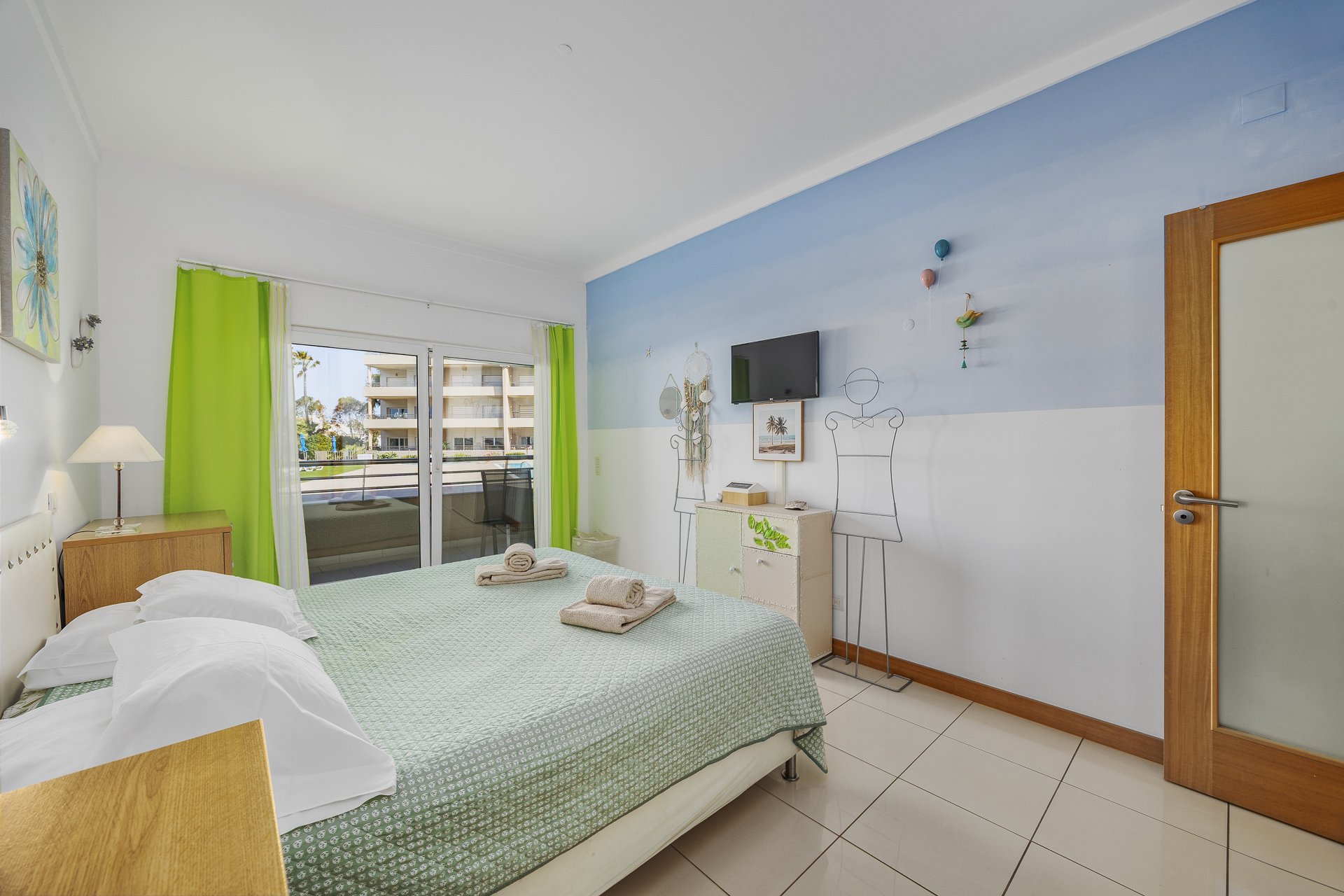 Bedroom with balcony access and pool view