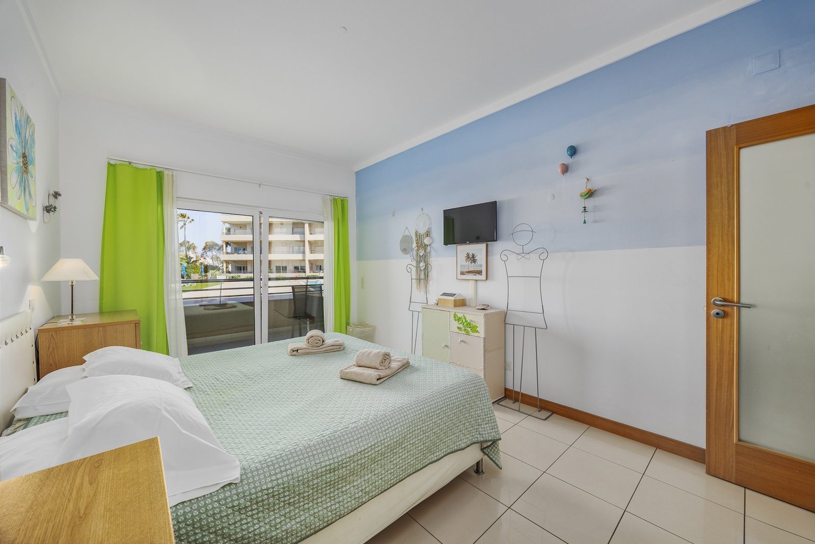 Bedroom with balcony access and pool view