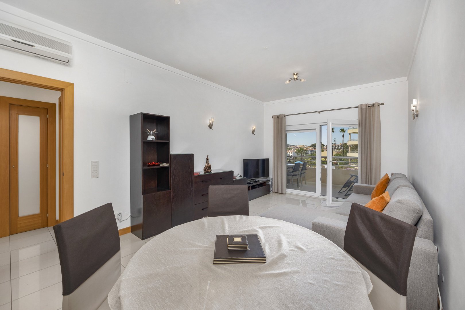 Living and dining area with coastal view through balcony doors