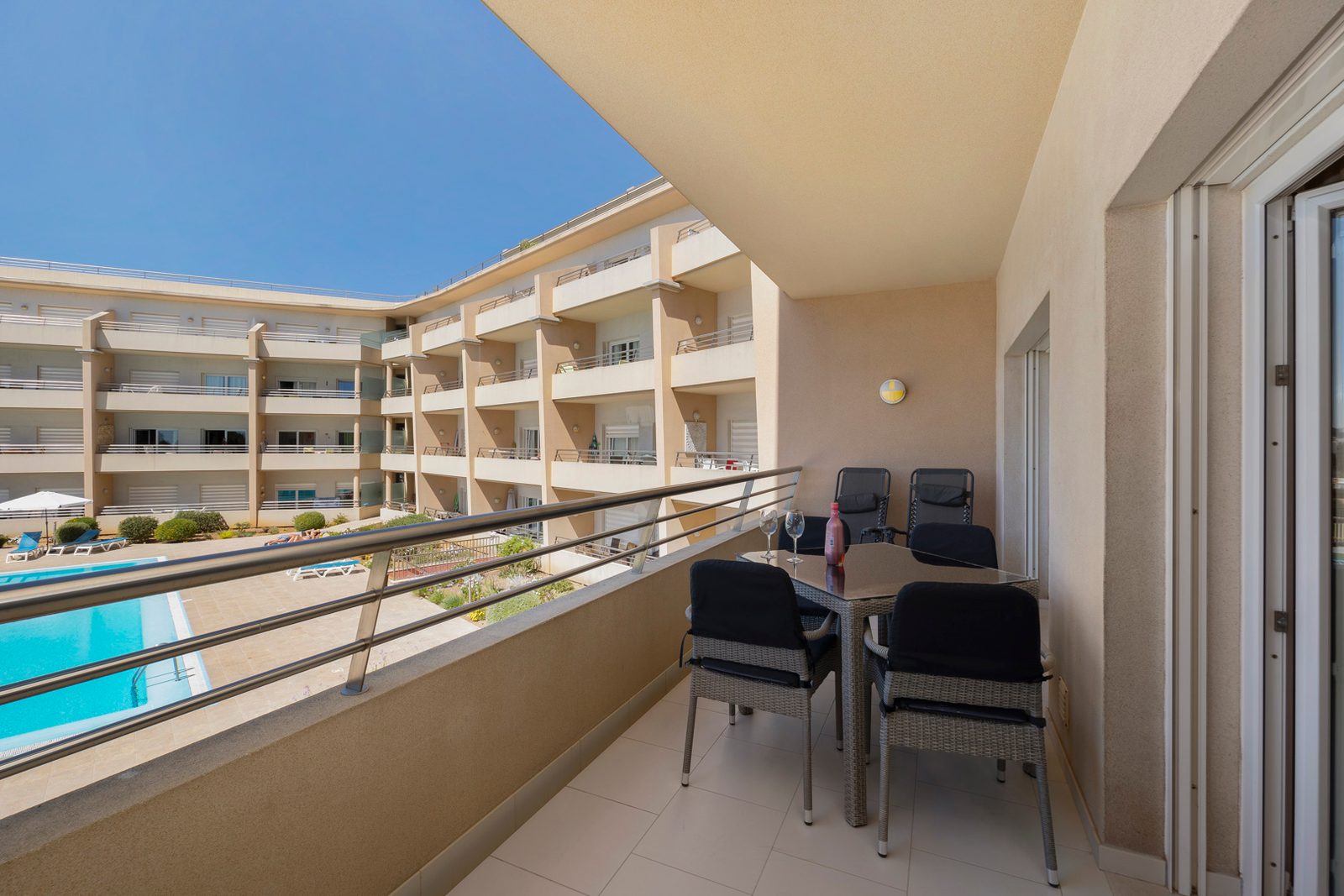 Balcony with table and chairs overlooking the pool