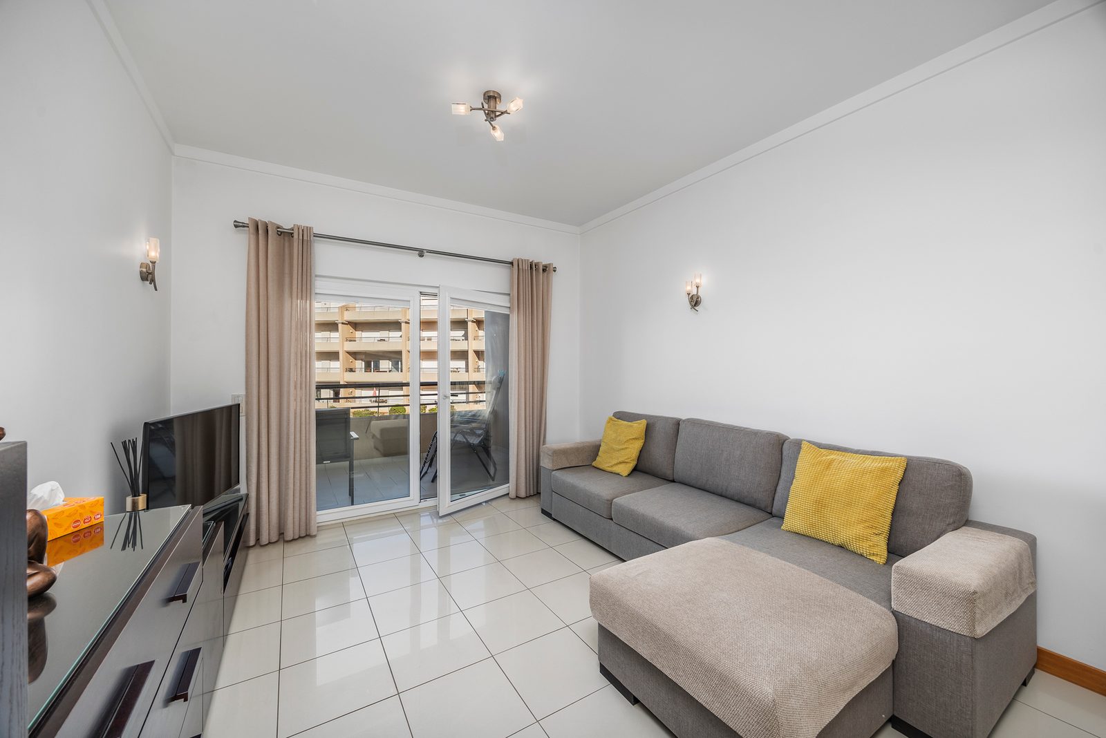Corner sofa and TV in the living room, facing the balcony