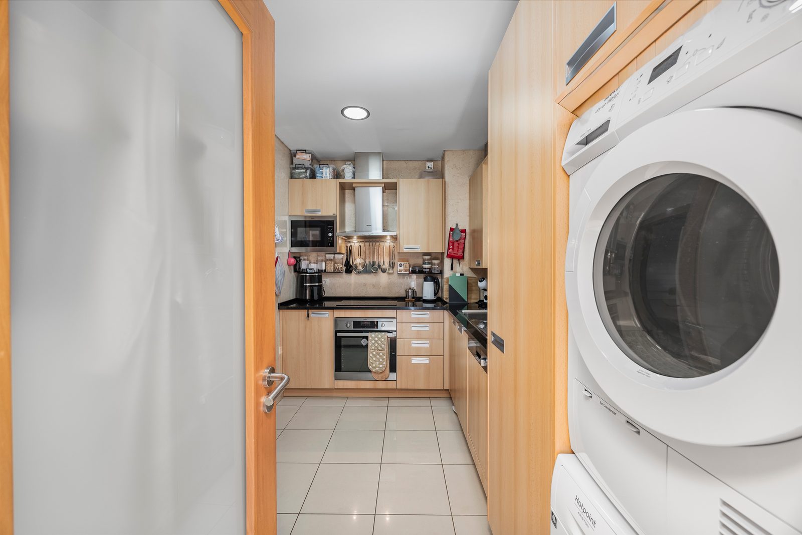 Kitchen with stacked washing machine and dryer