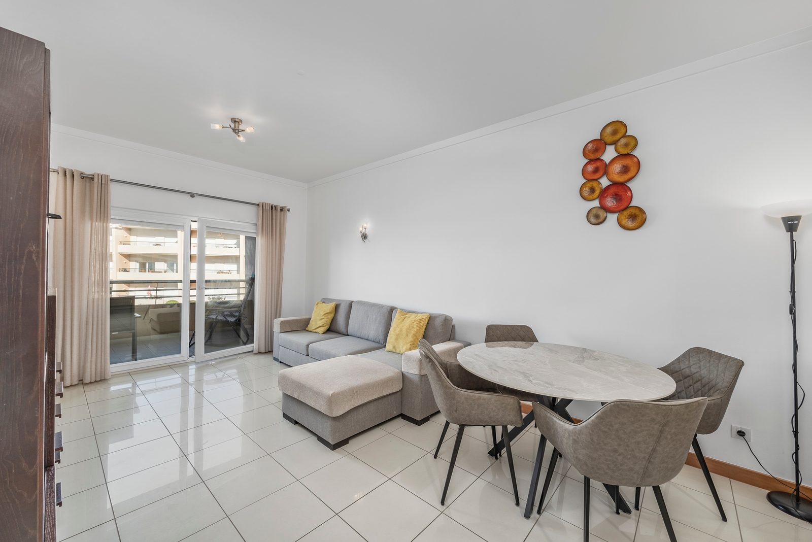 Living and dining area with round dining table and balcony doors