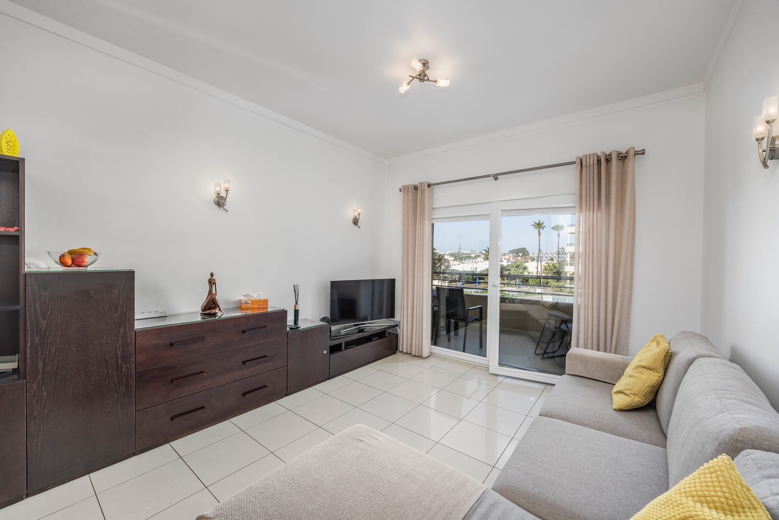 Living room with corner sofa, TV and balcony doors