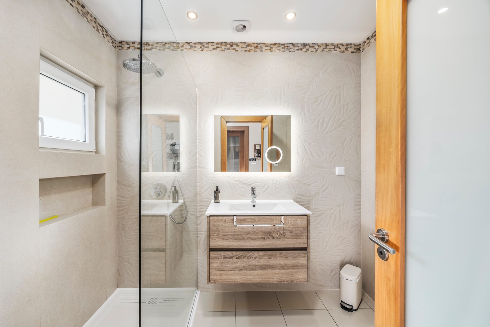 Modern bathroom with shower and illuminated mirror