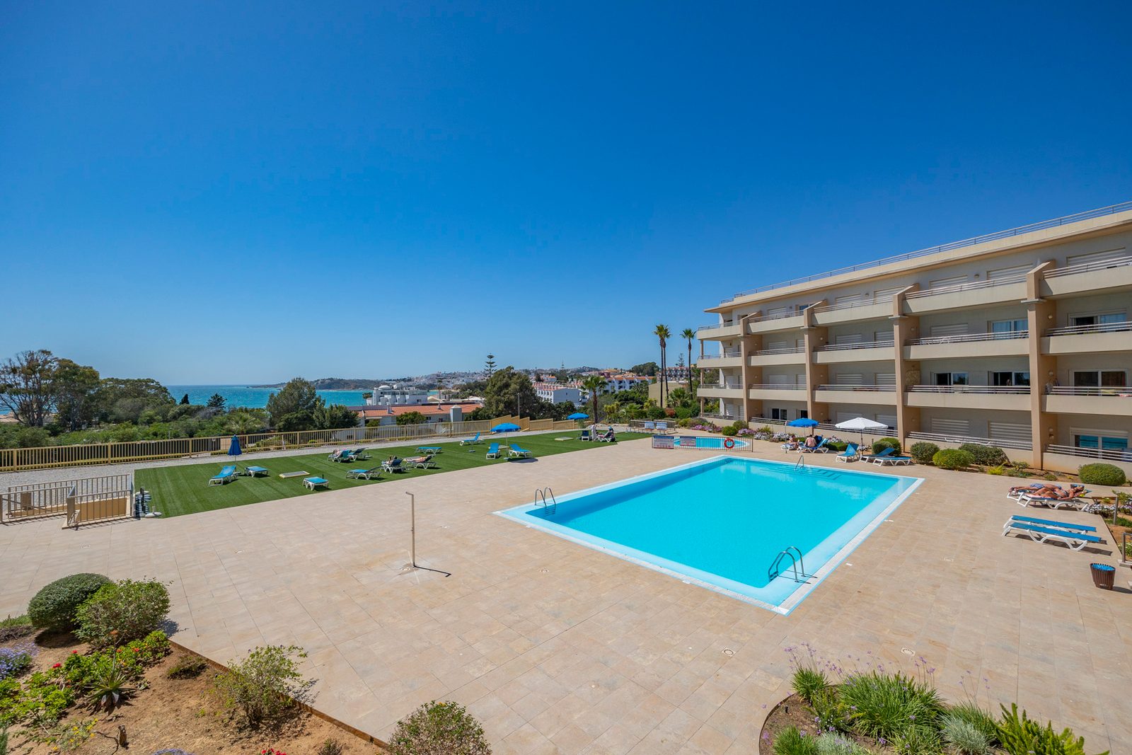 Swimming pool, sun terrace and gardens with sea views