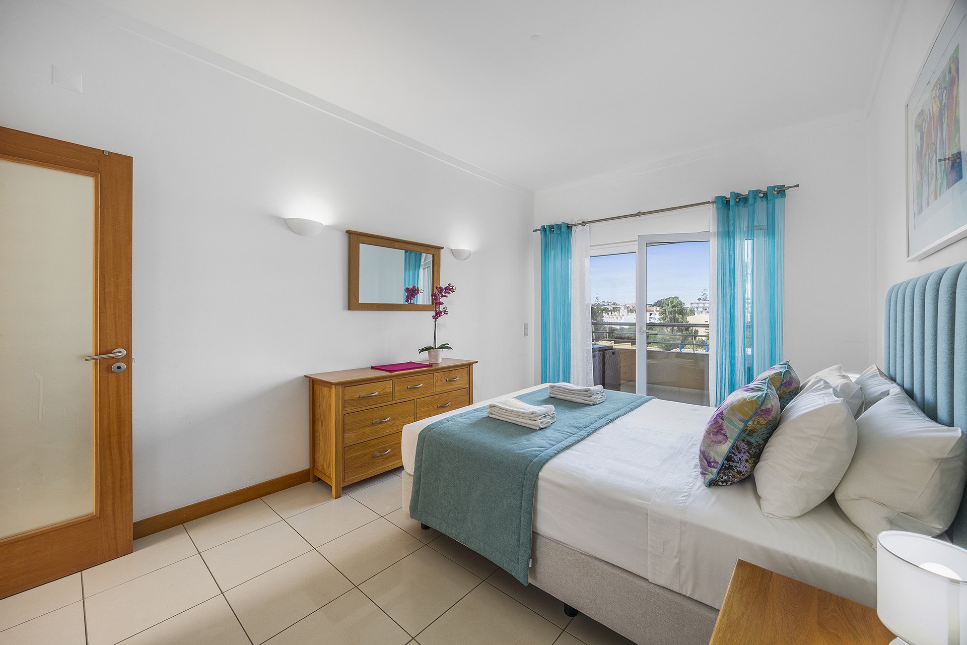 Bedroom with dressing table and town view balcony