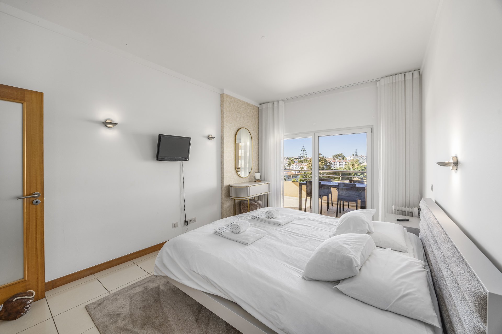 Bedroom with dressing table and balcony with dining set