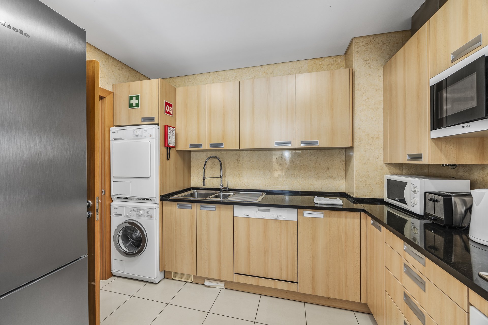 Kitchen with sink, dishwasher, and washer-dryer