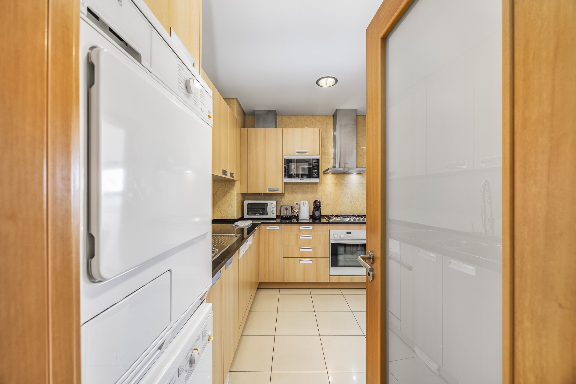Kitchen with washer-dryer tower and cabinetry