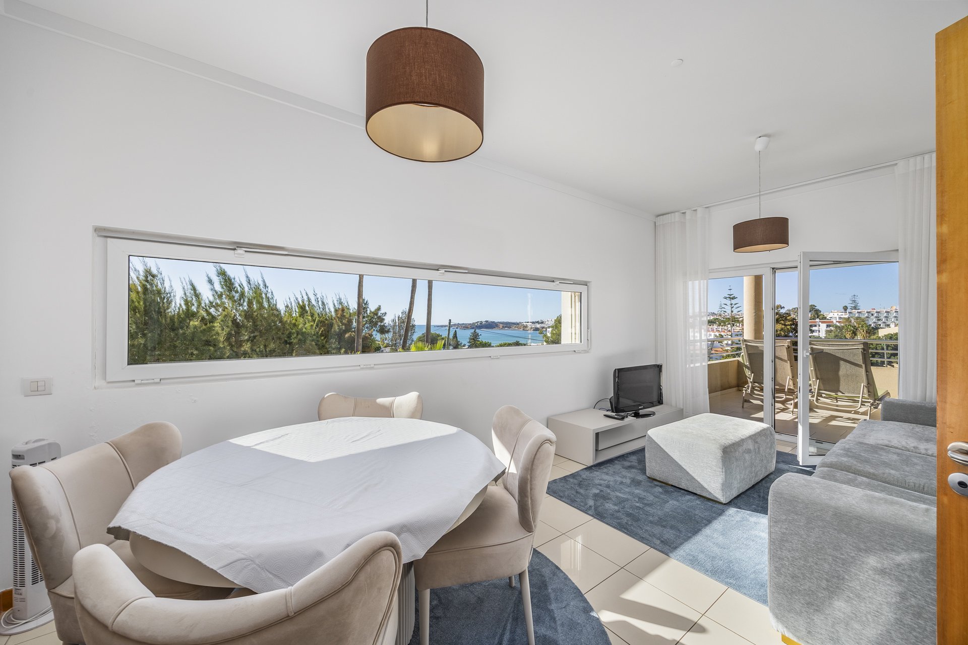 Living and dining area with sofa and terrace access