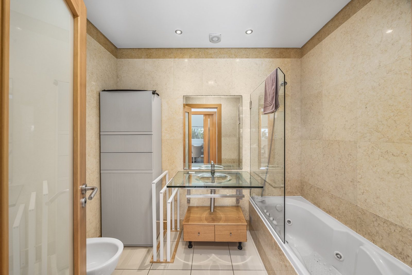 Bathroom with jacuzzi tub and glass sink