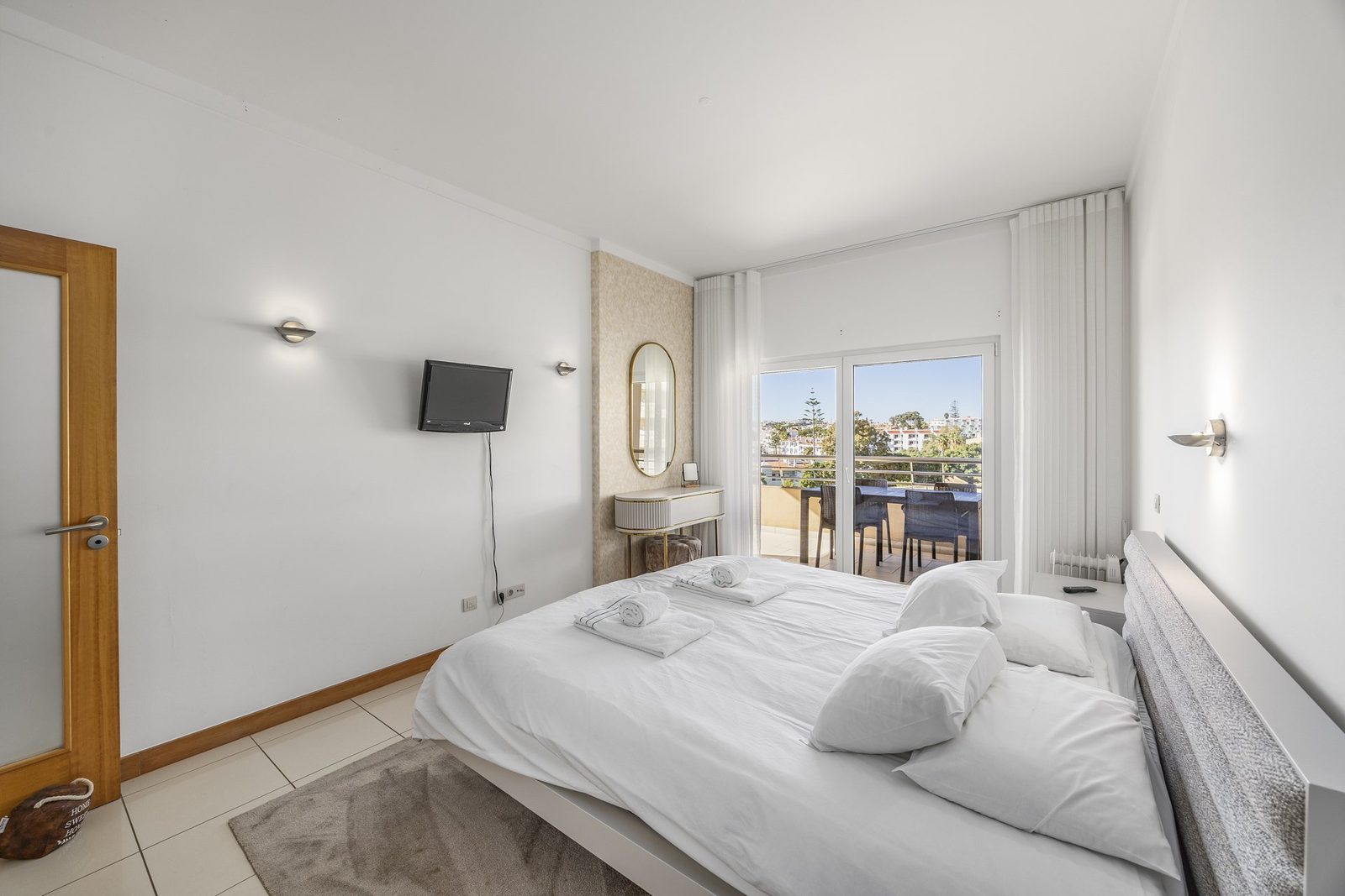 Bedroom with dressing table and balcony with dining set