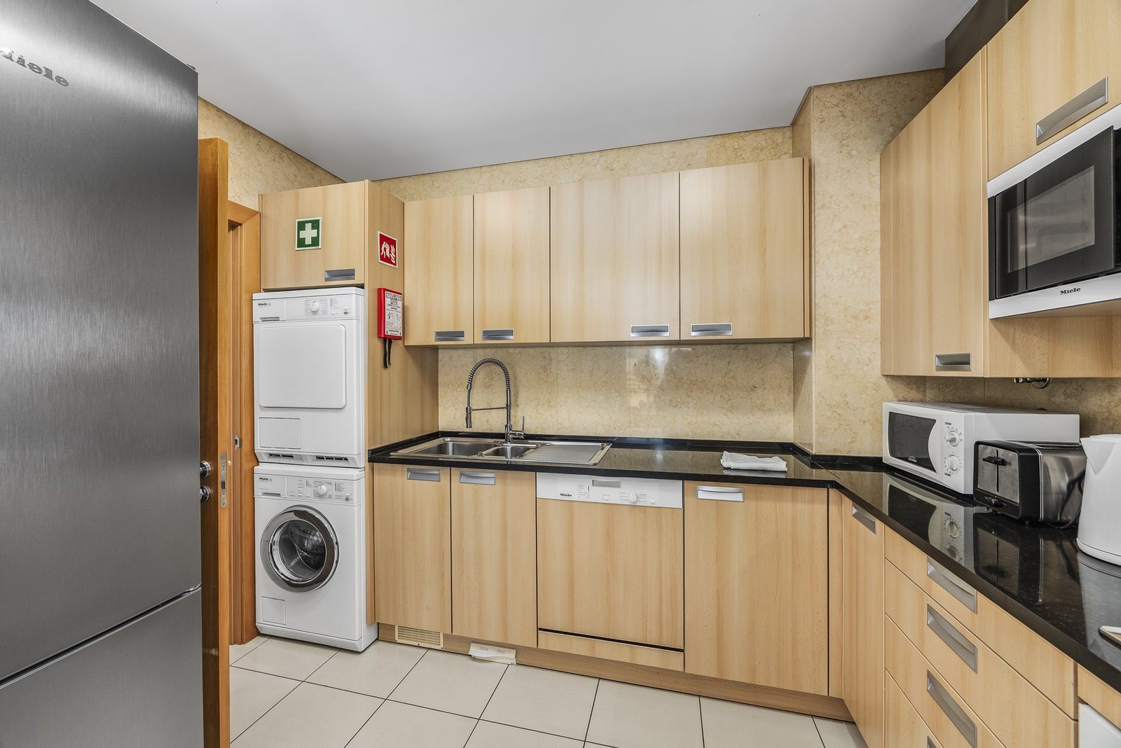 Kitchen with sink, dishwasher, and washer-dryer