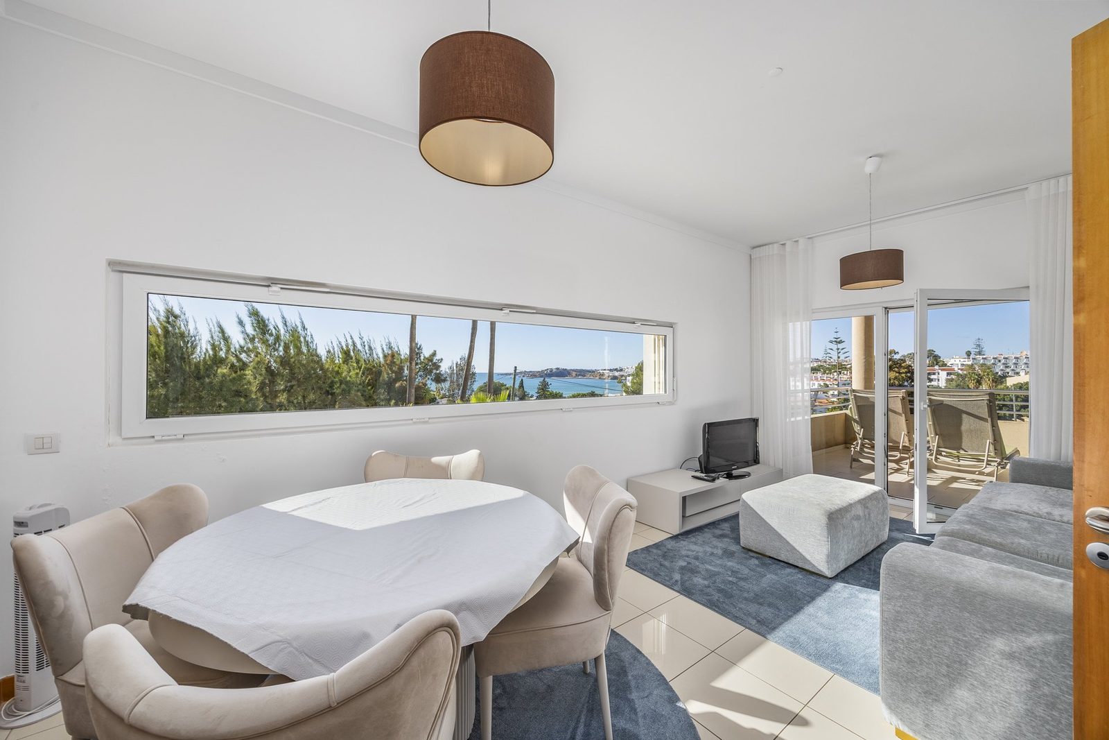 Living and dining area with sofa and terrace access