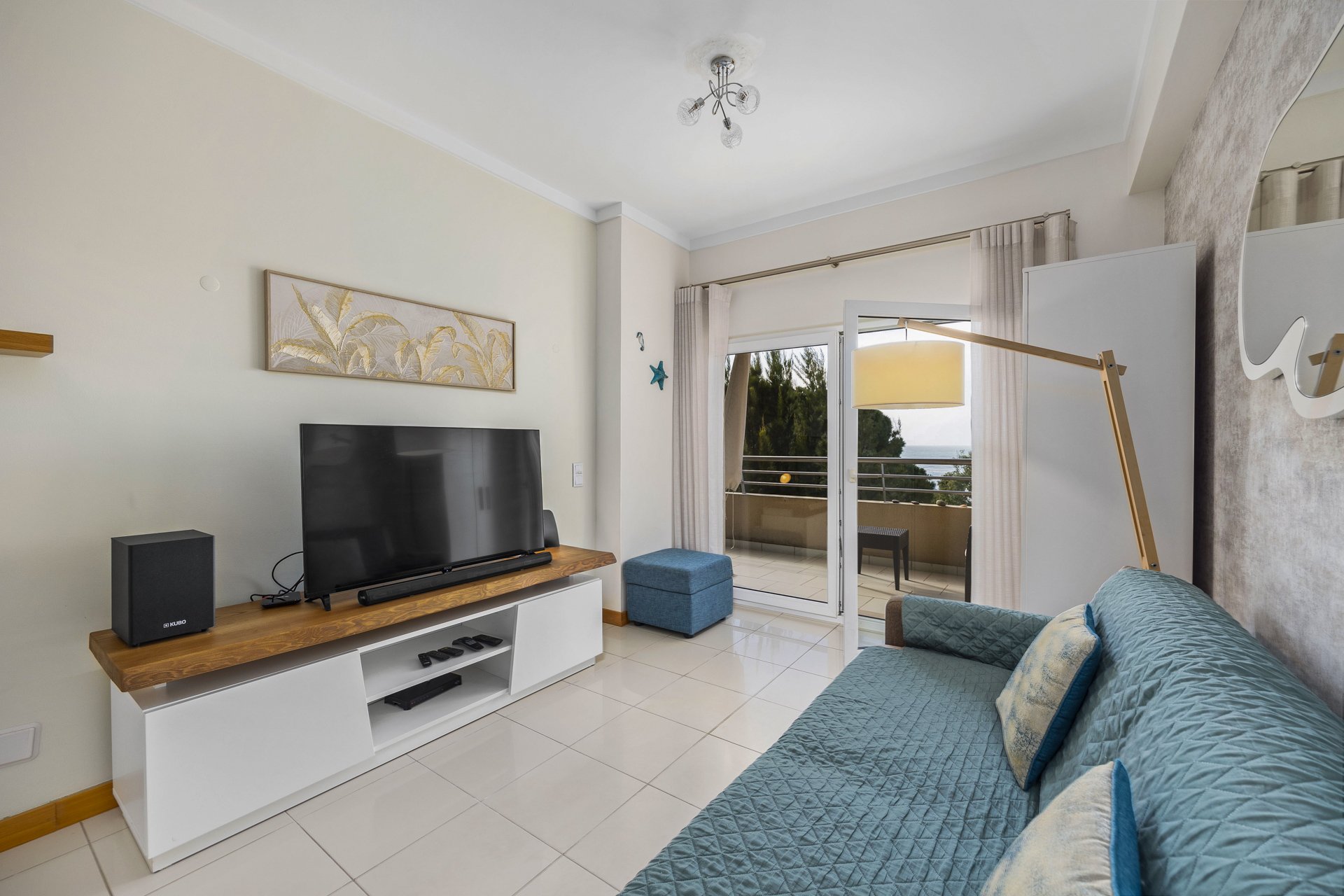 Living room with TV unit and balcony access