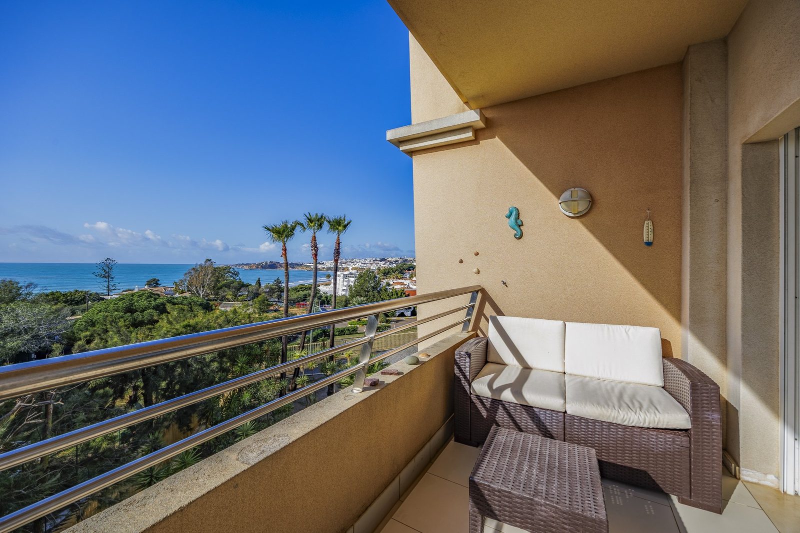 Balcony seating area with sea and palm tree view