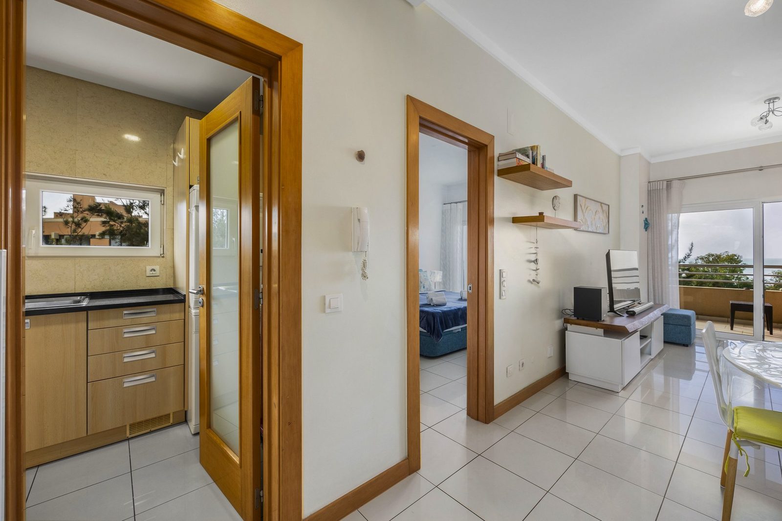 Hallway with kitchen, bedroom, and living area access