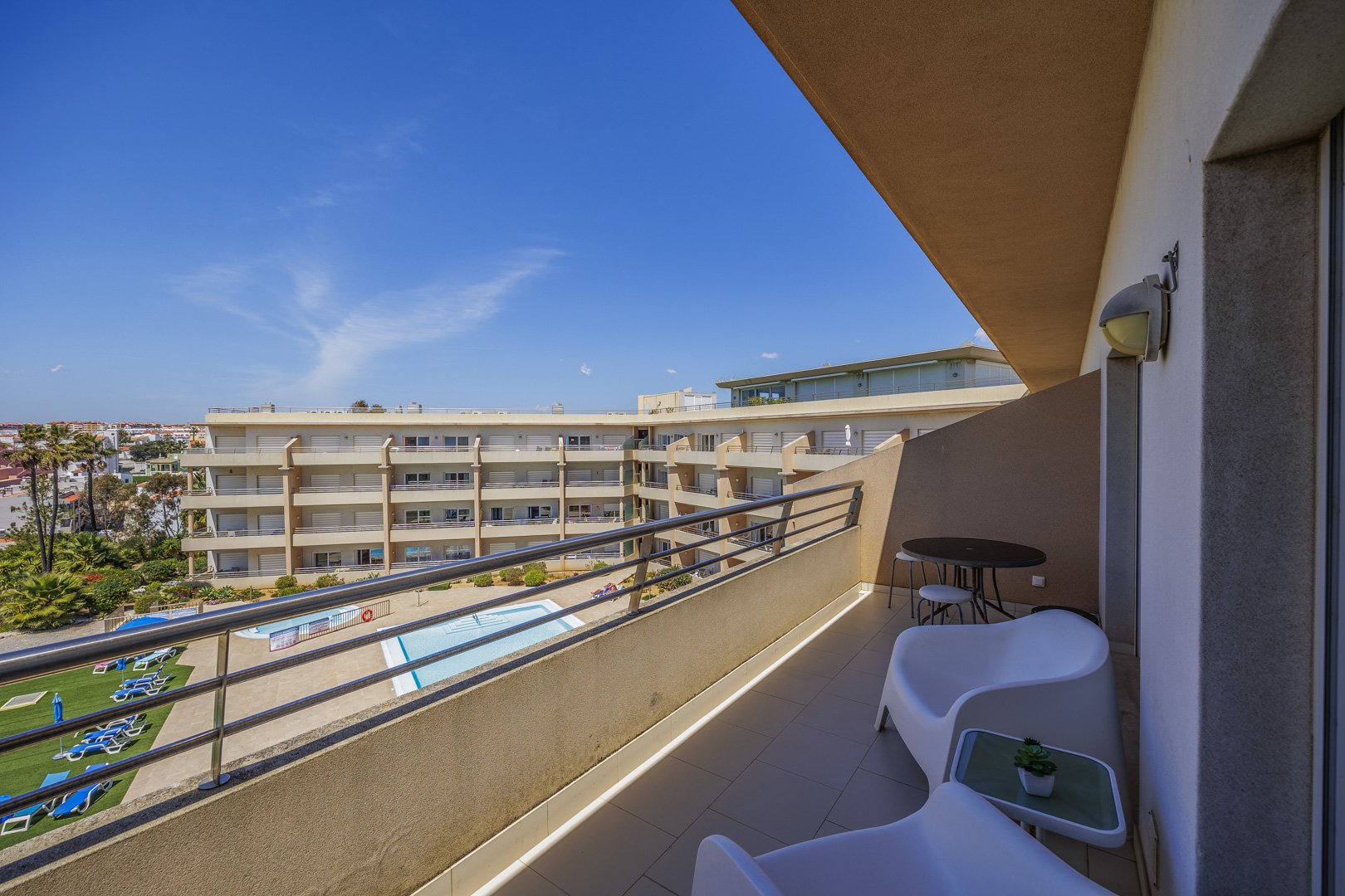 Balcony seating area overlooking the pool and building