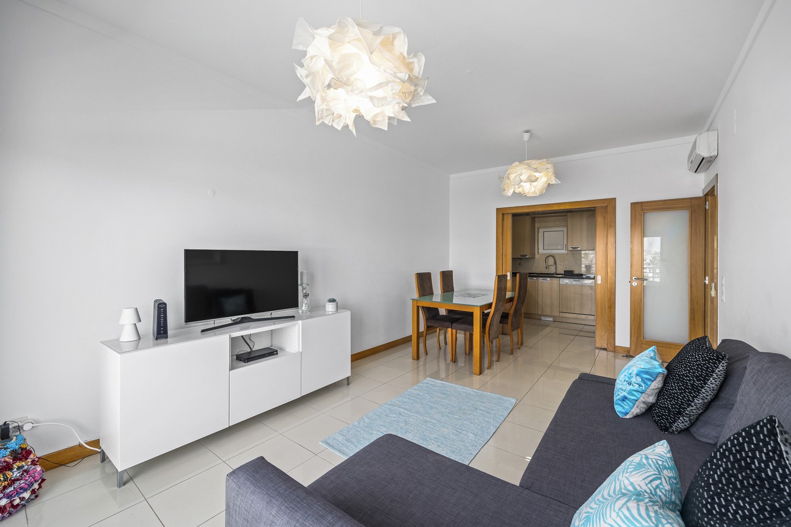 Living and dining area with TV, dining table, and kitchen access
