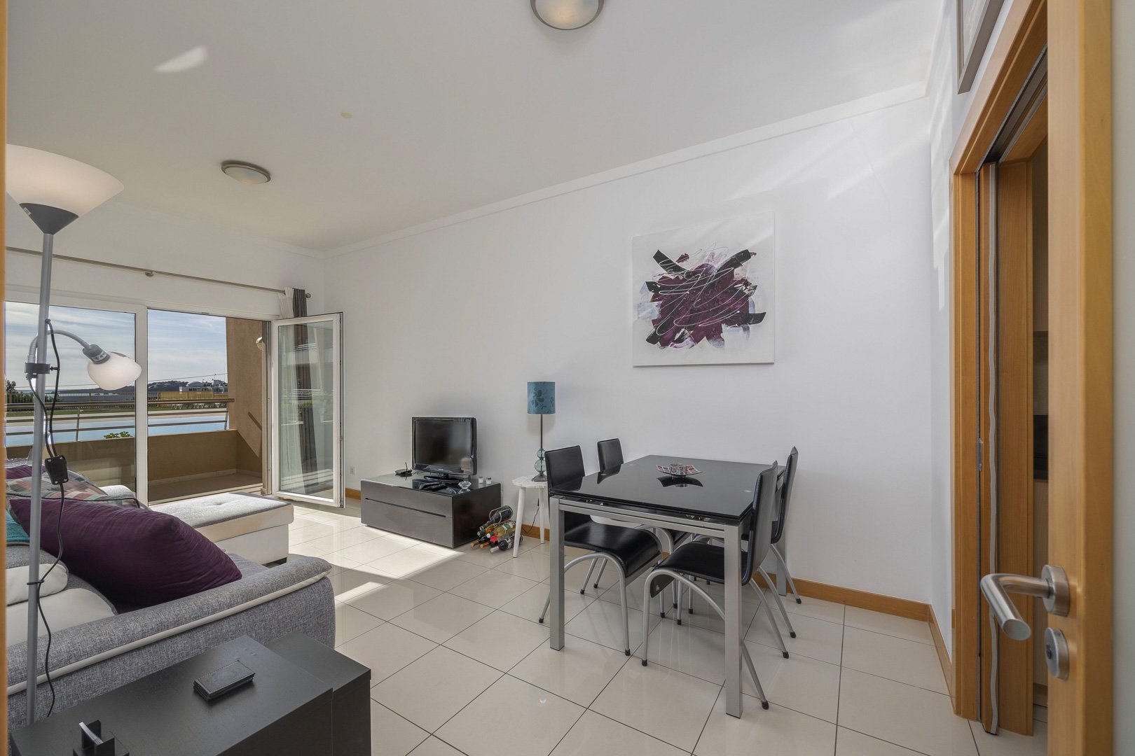 Living and dining area with sofa, TV, and dining table