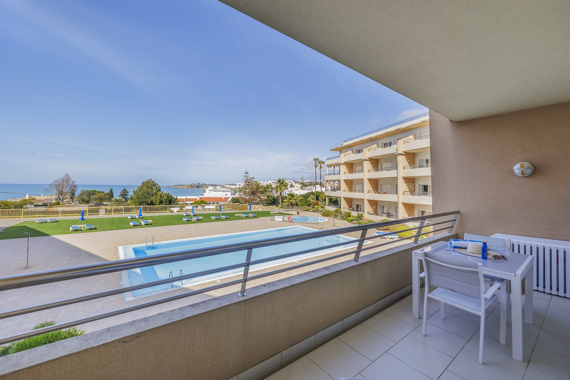 Balcony dining table overlooking the pool and coastline