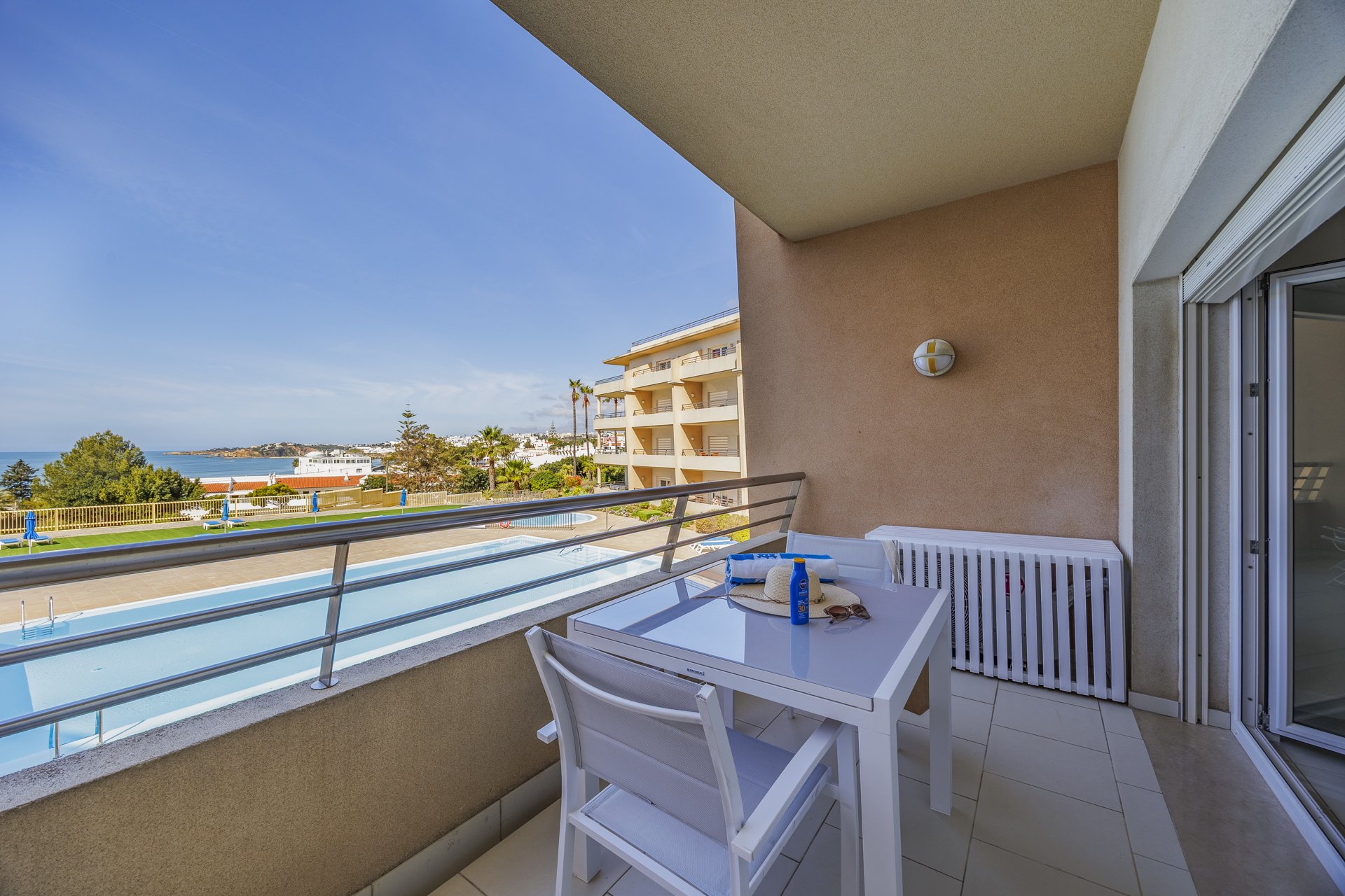 Balcony seating area overlooking the pool and coastline