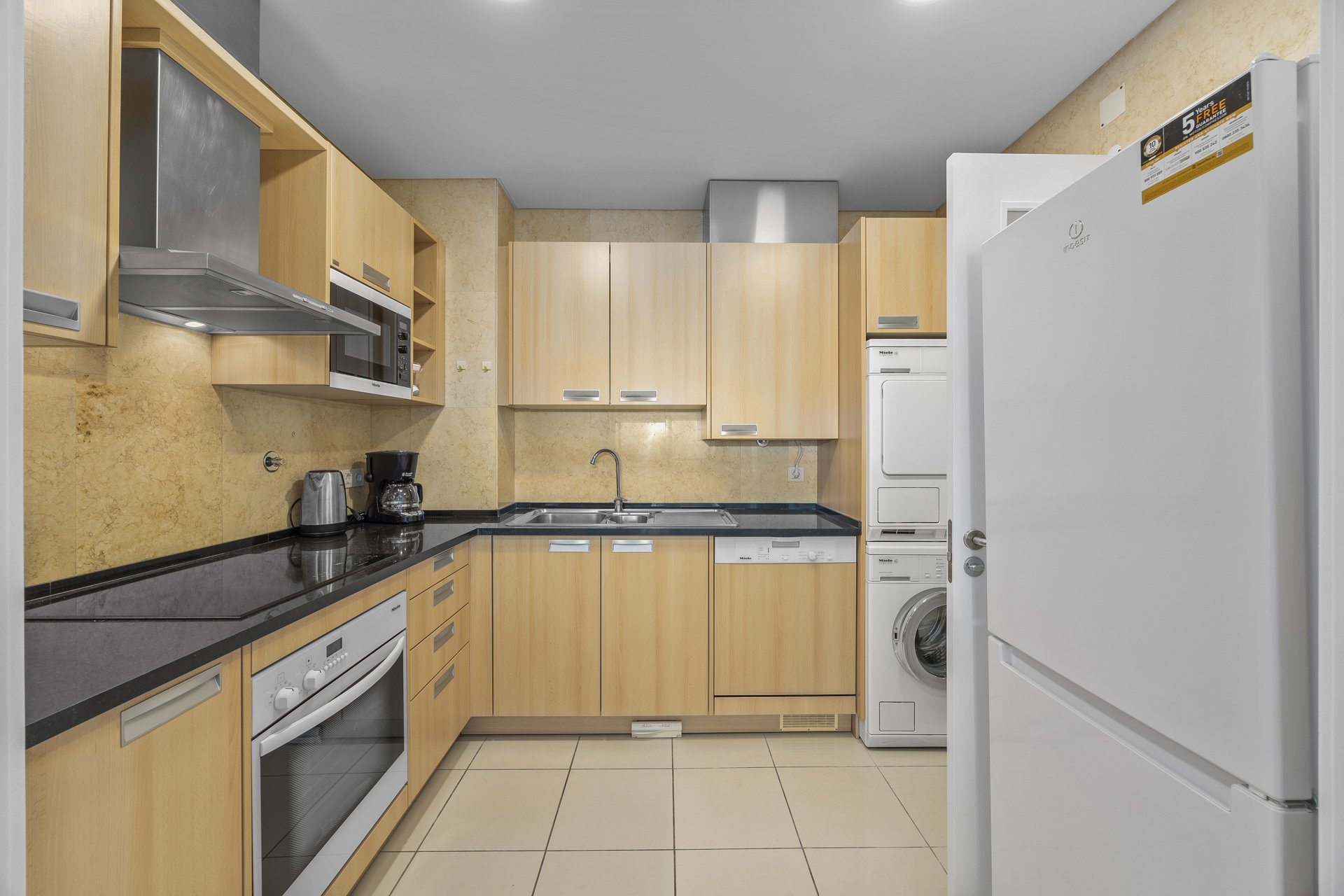Kitchen with fridge-freezer and stacked washer-dryer