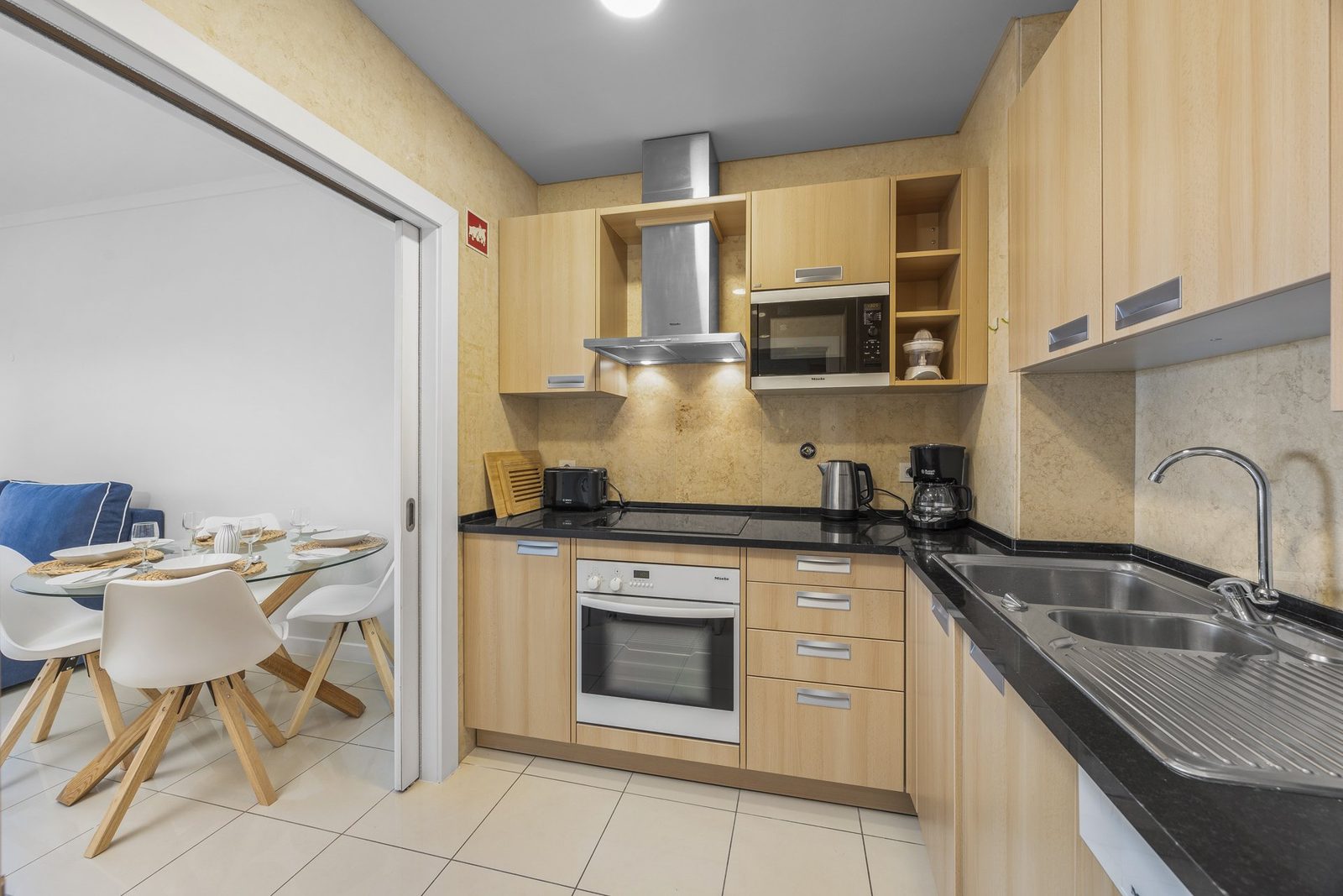 Kitchen with oven, hob, and dining area view