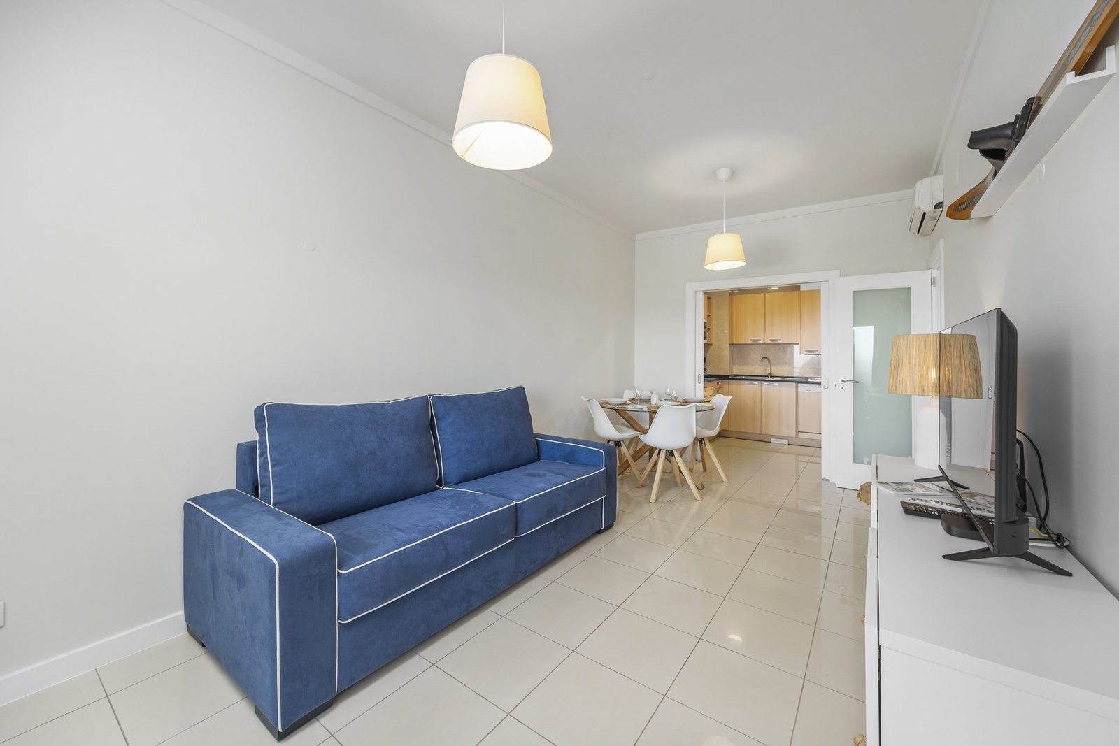Living room with sofa, dining table, and kitchen access