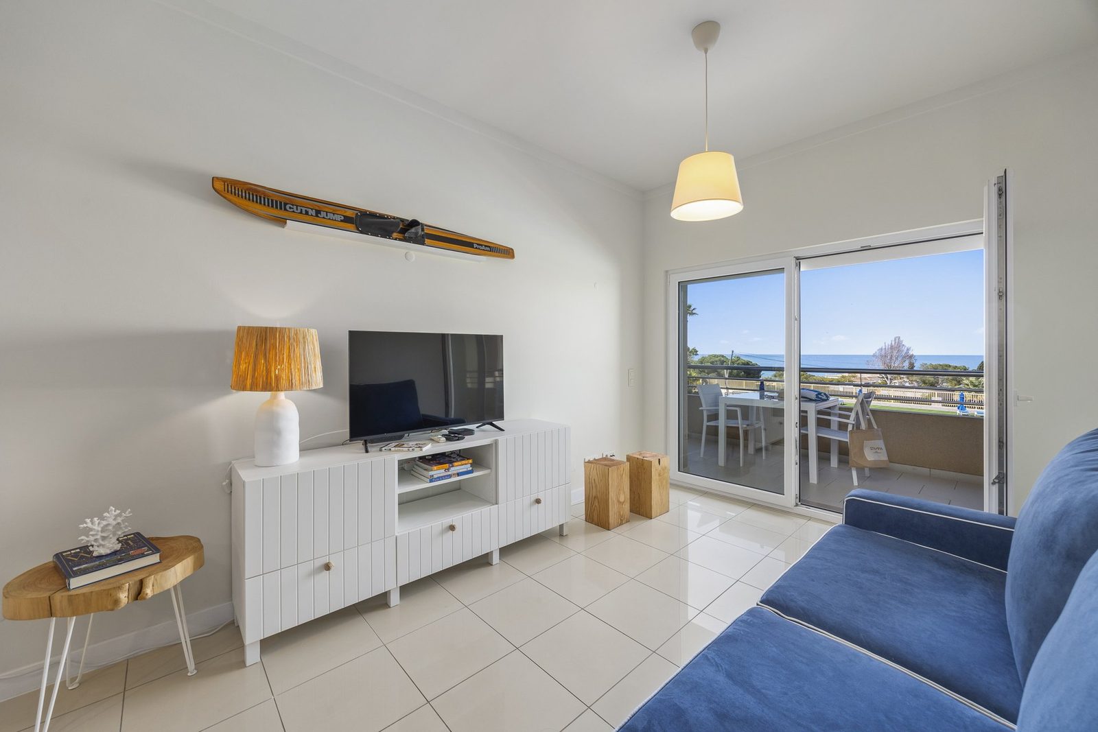 Living room with TV, waterski decor, and balcony access