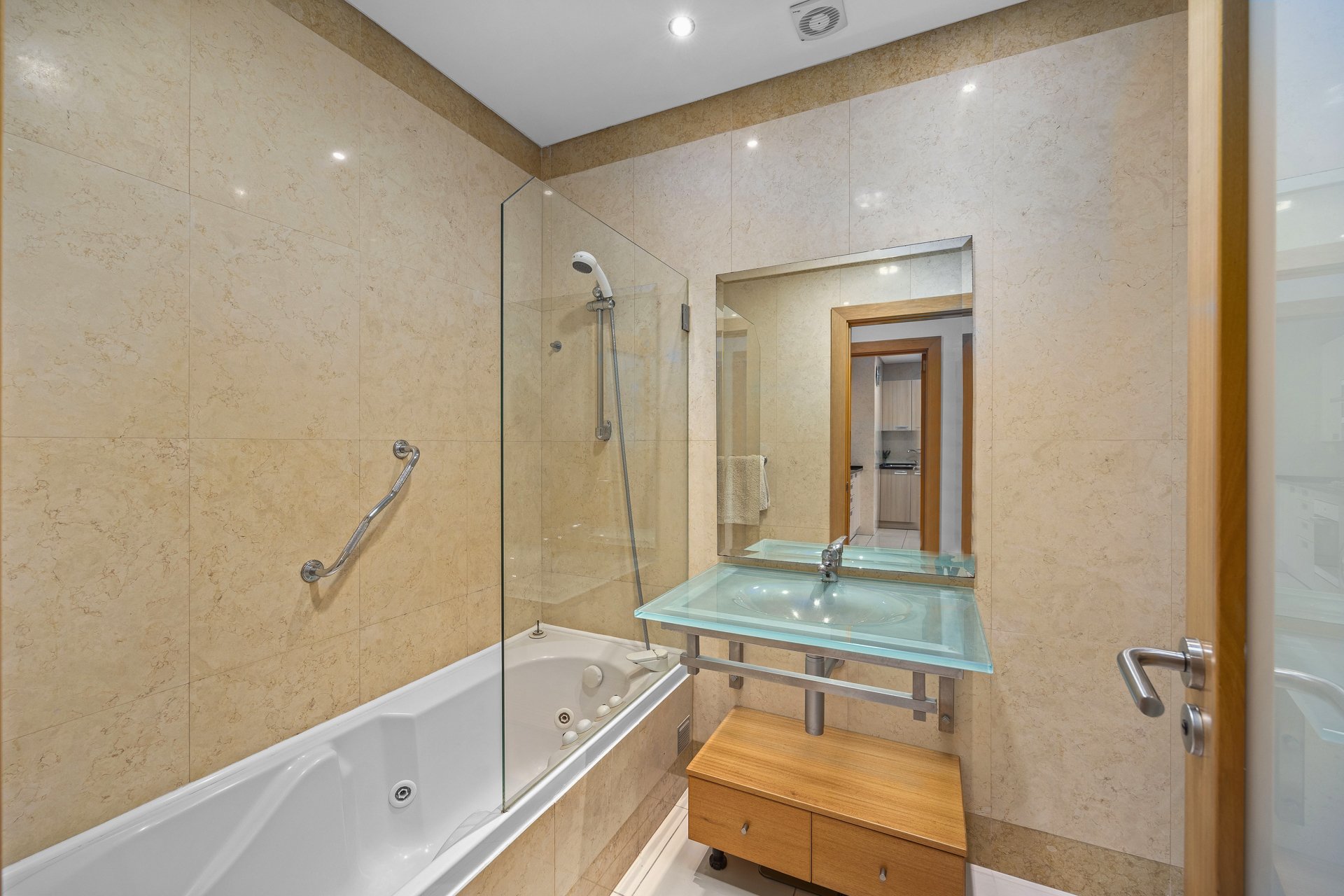 Bathroom with jacuzzi tub, glass sink, and walk-in shower