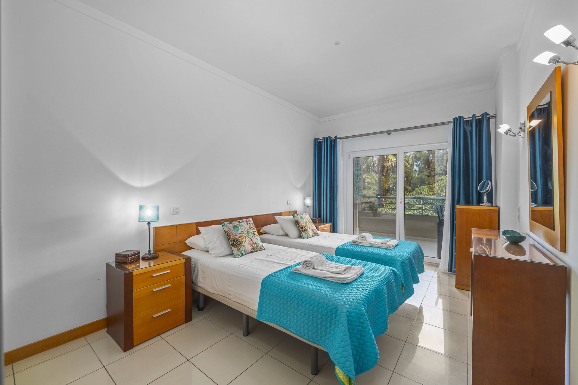 Twin bedroom with balcony access and treed view