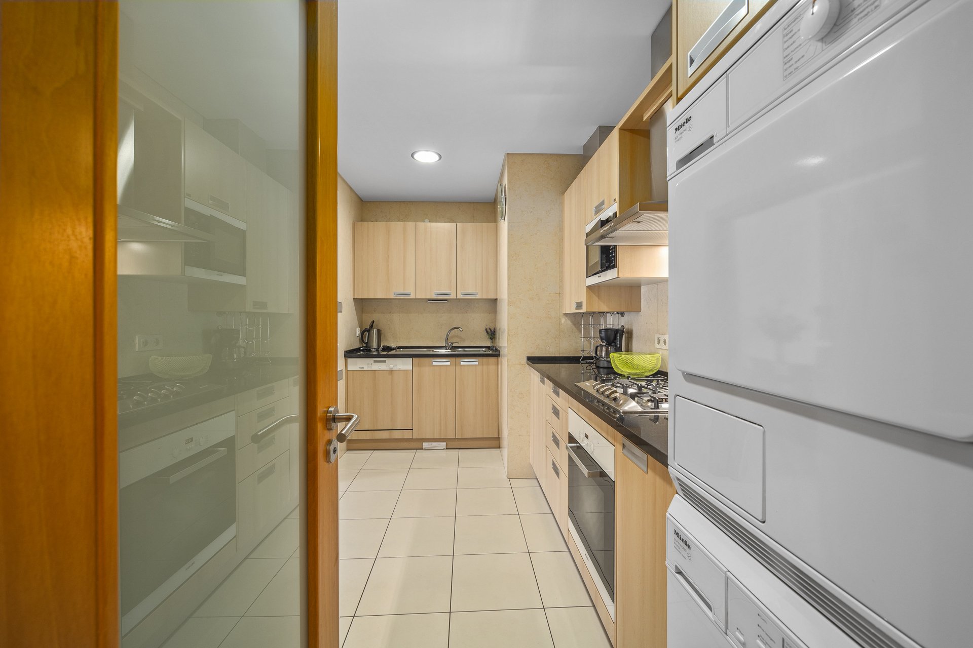 Kitchen with cabinets, oven, and hallway view