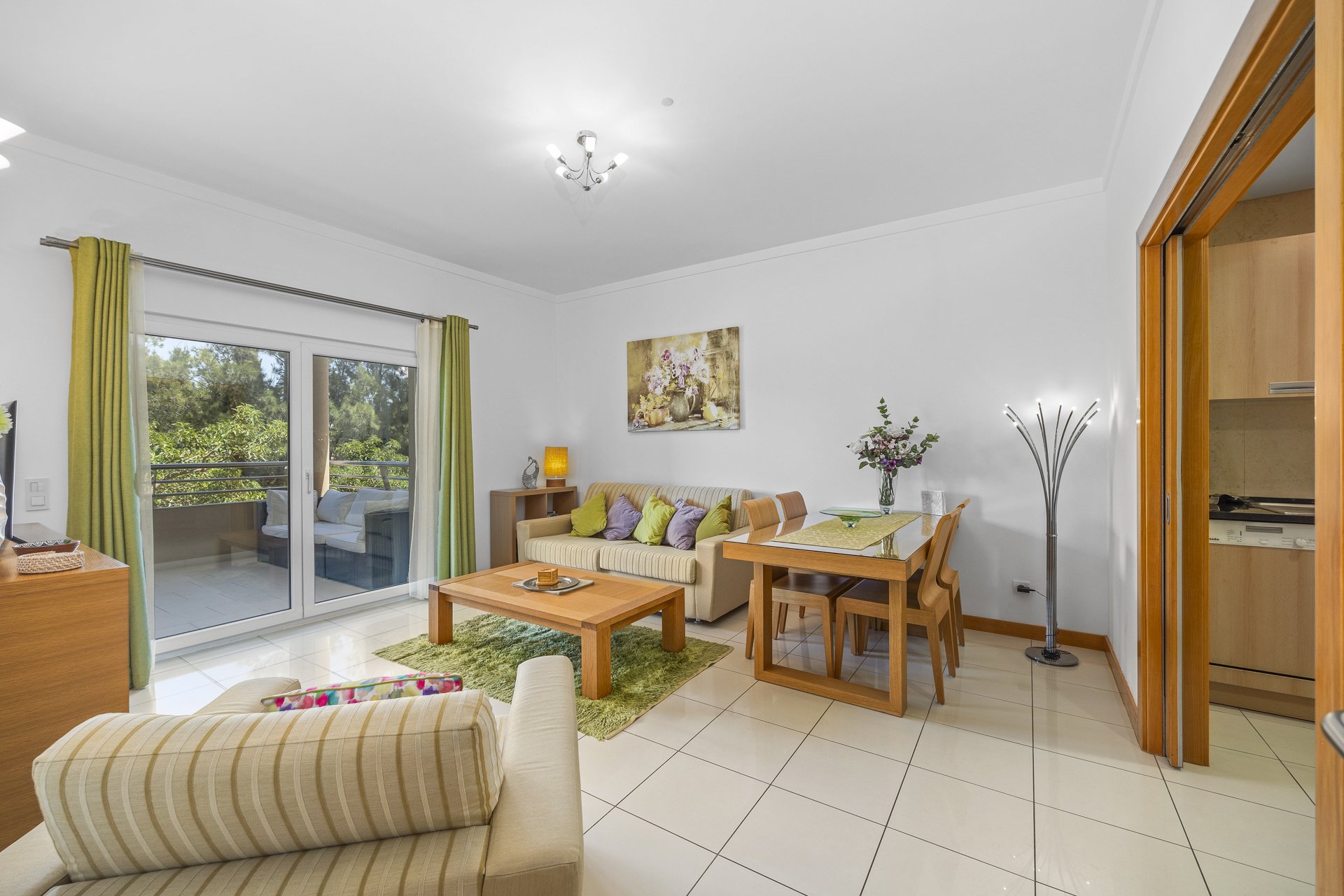 Living and dining area with dining table set and sofa, balcony access