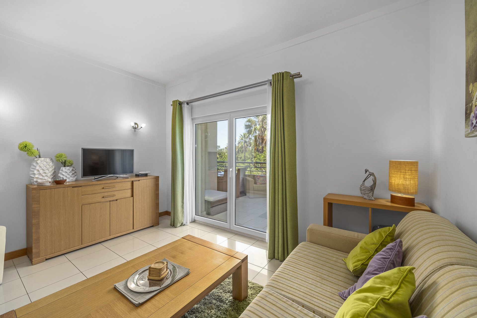 Living room with sofa, coffee table, and balcony access