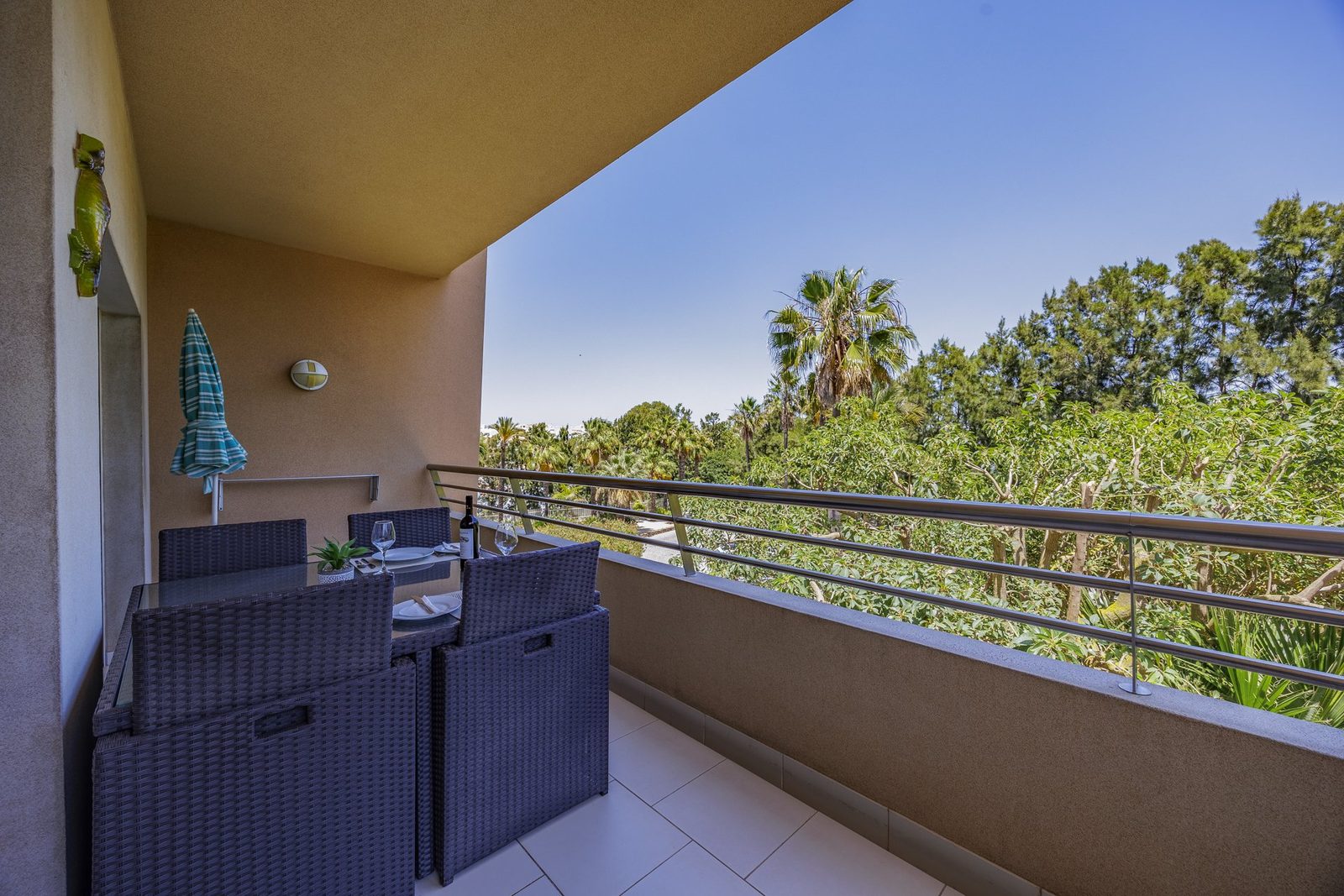 Balcony seating area with a decorative seahorse and treed view