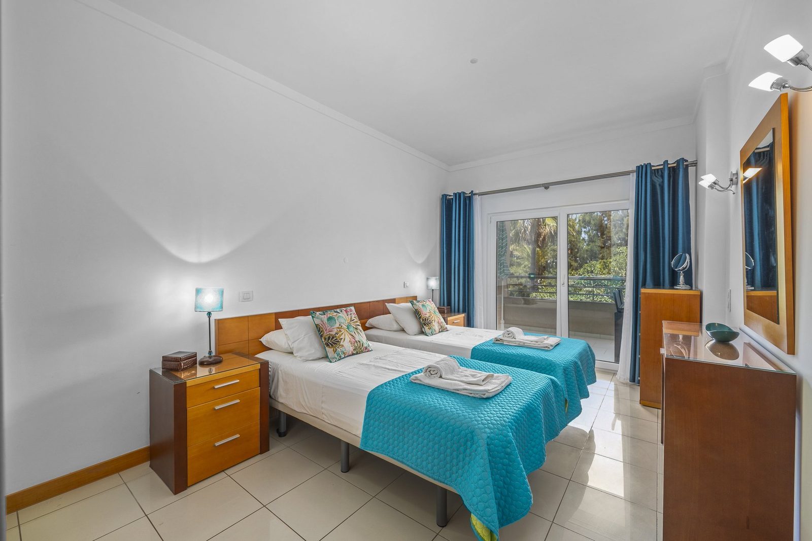 Twin bedroom with balcony access and treed view