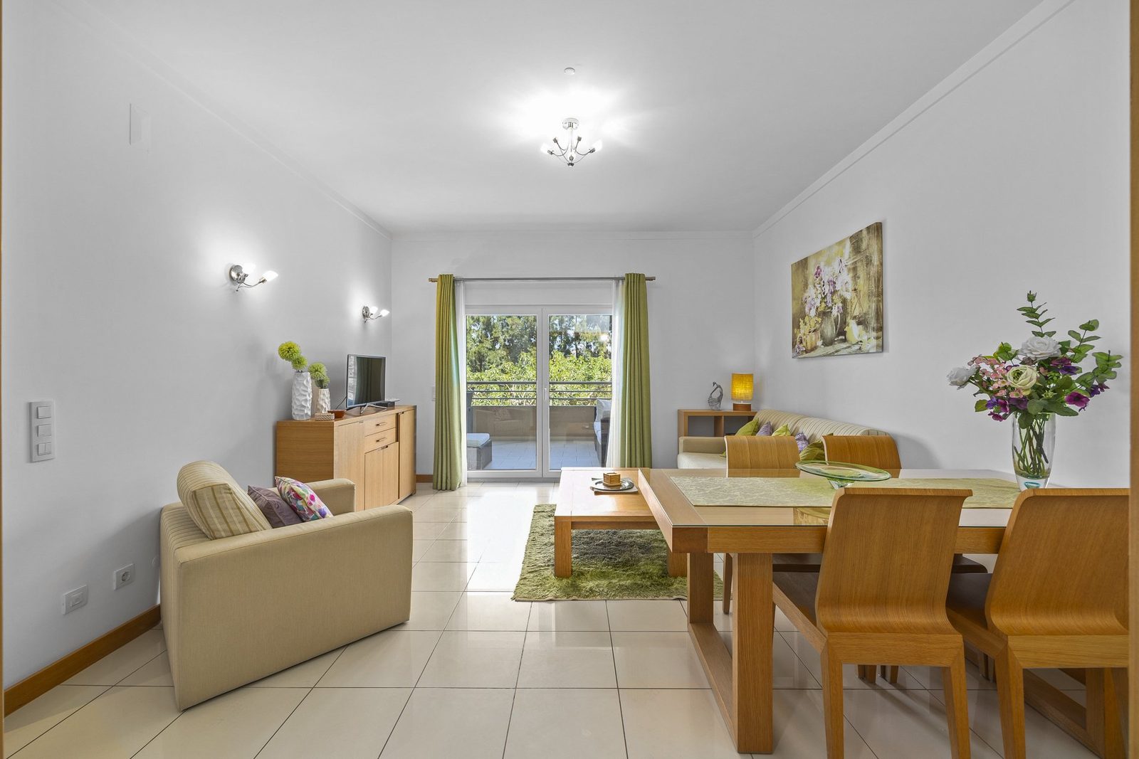 Living and dining area with sofa, dining table, and balcony access