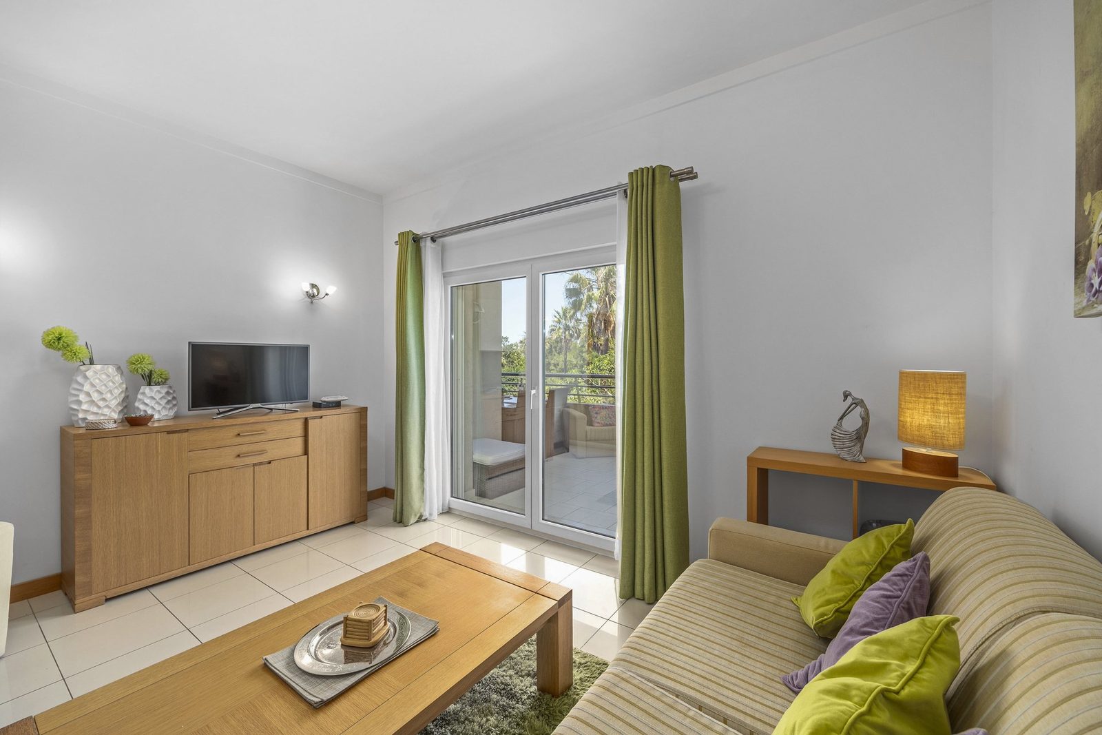 Living room with sofa, coffee table, and balcony access