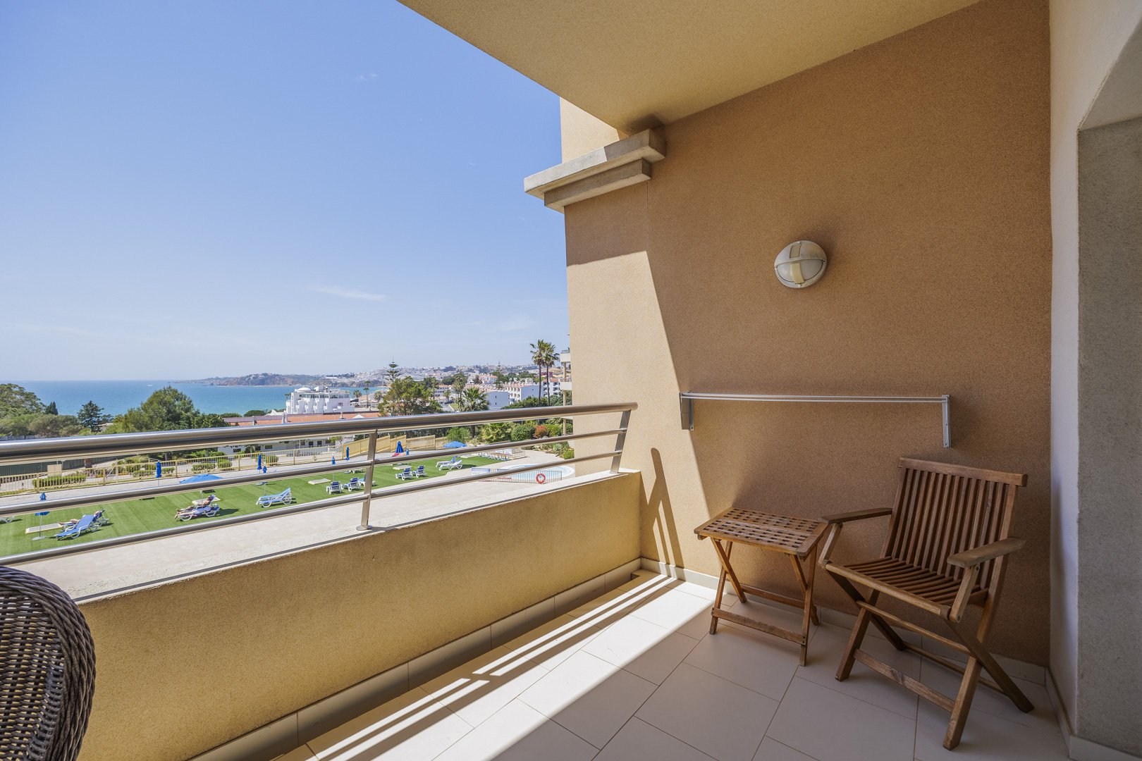 Balcony seating area overlooking the pool and coastline